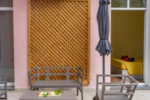 a patio with two chairs and an umbrella at Furnas Cozy Inn in Furnas