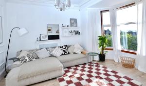 a white living room with a couch and a rug at Carmona Bank in Dunoon