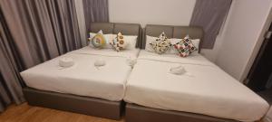 a bedroom with two beds with white sheets and pillows at the time pool villa พัทยา in Ban Bung