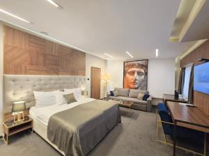 ein Schlafzimmer mit einem Bett und einer Couch und einem Fernseher in der Unterkunft Ilica Boutique Apartments in Zagreb