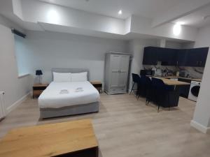 a bedroom with a white bed and a kitchen at Abbey Apartments in Dublin