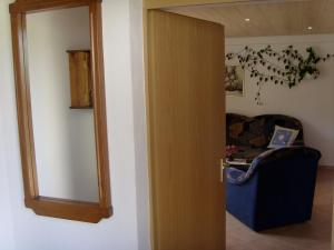 une porte ouverte avec une chaise et un miroir dans l'établissement Ferienwohnung Mit Blick Zur Wallfahrtskirche, à Ebensfeld