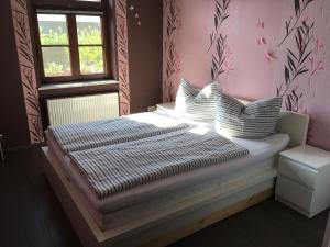 une chambre avec un lit avec des oreillers et une fenêtre dans l'établissement Gemütliches Ferienhaus In Godow Mit Terrasse, à Kargow