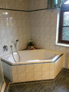 La salle de bains est pourvue d'une baignoire et d'une douche. dans l'établissement Gemütliches Ferienhaus In Godow Mit Terrasse, à Kargow