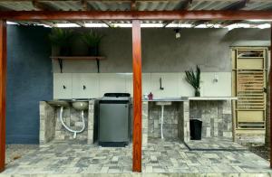 an outdoor kitchen with a stove and a counter at Hospedaria Caripí in Barcarena