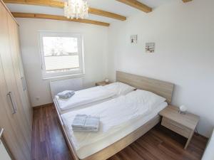 une chambre avec un grand lit blanc et une fenêtre dans l'établissement Ferienhaus Mit Atemberaubendem Blick Auf Den See, à Wiefelstede