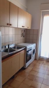 een keuken met een spoelbak en een wasmachine bij Appartamento Guitgia in Lampedusa