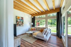 ein Wohnzimmer mit einem Sofa und großen Fenstern in der Unterkunft Nette Ferienwohnung in Unterort mit Garten, Terrasse und Grill und Panoramablick in Feistritz ob Bleiburg