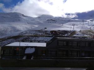 un bâtiment avec de la neige au sommet d'une montagne dans l'établissement Studio Cabine 6 pers avec équipements confort, Piau-Engaly - FR-1-457-200, à Aragnouet