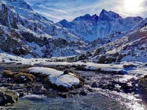 une montagne enneigée avec une rivière et des montagnes enneigées dans l'établissement Appartement Central avec Parking à Cauterets - FR-1-812-1, à Cauterets 3 autres photos