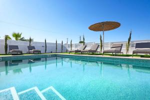 ein Swimmingpool mit Stühlen und einem Sonnenschirm in der Unterkunft Princess Anne Luxury Villa - Large Pool in Protaras + 20 Fotos