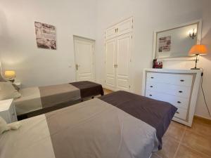 ein kleines Schlafzimmer mit 2 Betten und einer Kommode in der Unterkunft Villa Las Golondrinas in Periana