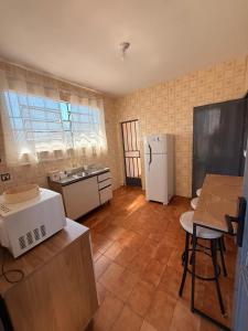a kitchen with a white refrigerator and a table at Casa do Mauro in Foz do Iguaçu