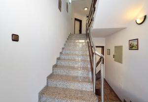een trap in een wit gebouw met een metalen leuning bij Apartment Sanja in Vodice