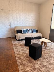 a room with a bed with blue pillows and a table at Casa do Mauro in Foz do Iguaçu