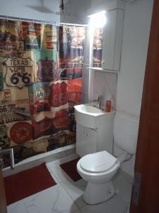 a bathroom with a toilet and a shower curtain at cabaña el mirador in Tanti
