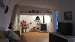 a living room with a tv and a stove at Pico Piedras in Zújar