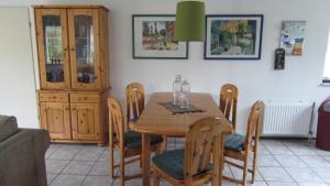 a dining room with a wooden table and chairs at Gemütliches Haus Mit Komplett Umzäuntem Garten in Wemeldinge
