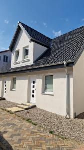 a white house with a black roof at Stadtnah an der Förde 57 01 in Flensburg