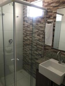 a bathroom with a glass shower and a sink at AP 104 - Flecheiras Residence in Flecheiras