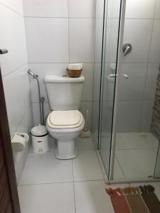 a bathroom with a toilet and a glass shower at AP 104 - Flecheiras Residence in Flecheiras +8 photos