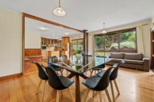 ein Esszimmer und ein Wohnzimmer mit einem Glastisch und Stühlen in der Unterkunft Gilderoy Valley Views- Farm house in Gladysdale