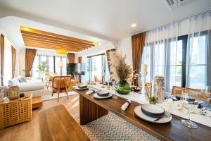 soggiorno con tavolo da pranzo e soggiorno di Phu Talae Villa Rawai Beach a Ban Klang