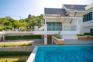 una casa con piscina di fronte a una casa di Phu Talae Villa Rawai Beach a Ban Klang