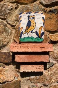 ein Kissen mit einem Vogel an einer Steinmauer in der Unterkunft Ferienhaus für 2 Personen ca 56 qm in Alajar, Andalusien Provinz Huelva in Alájar