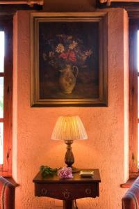 ein Tisch mit einer Lampe und einem Gemälde an der Wand in der Unterkunft Ferienhaus für 2 Personen ca 56 qm in Alajar, Andalusien Provinz Huelva in Alájar