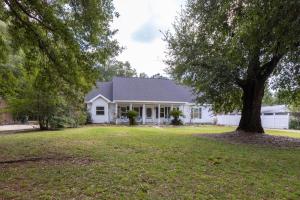 una casa bianca con un albero nel cortile di Southern Charm a Bon Secour