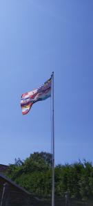 un drapeau battant pavillon dans le ciel à côté d'un bâtiment dans l'établissement Wohnung In Jameln Mit Garten, Grill Und Terrasse, à Jameln