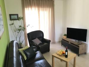 a living room with a leather chair and a television at Gemütliches Haus In Drvenik Mali Mit Meerblick in Dolići