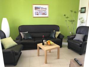 a living room with two black couches and a table at Gemütliches Haus In Drvenik Mali Mit Meerblick in Dolići