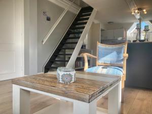 un salon avec une table et un escalier dans l'établissement 120 Dijkrose, à Anjum 31 autres photos