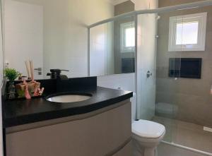 un bagno con lavandino, WC e doccia di Casa a 100 metros do mar a Capão da Canoa Altre 15 foto