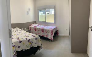 una stanza con due letti e una finestra di Casa a 100 metros do mar a Capão da Canoa