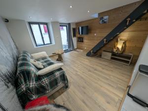 een woonkamer met een bank en een trap bij Maisonnette cosy montagne in La Garde