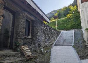 een stenen gebouw met een trap naast een deur bij Maisonnette cosy montagne in La Garde +7 foto's