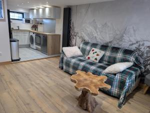 a living room with a couch and a kitchen at Maisonnette cosy montagne in La Garde