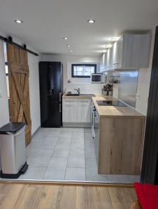 een keuken met een zwarte koelkast en een aanrecht bij Maisonnette cosy montagne in La Garde