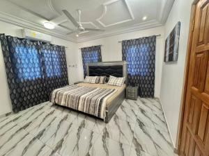 Ένα ή περισσότερα κρεβάτια σε δωμάτιο στο Charming 2 Bedroom House in Vibrant Ablekuma Olebu