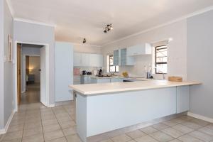 a kitchen with white cabinets and a large island at Sea Bliss in Kenton on Sea +11 photos