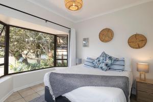 a bedroom with a bed and a large window at Sea Bliss in Kenton on Sea