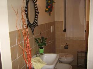 une salle de bain avec un lavabo, des toilettes et un miroir dans l'établissement Ferienwohnung Rose In Cagli, à Cagli 14 autres photos
