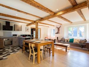 eine Küche und ein Wohnzimmer mit einem Holztisch in der Unterkunft Maison de village rénovée pour 12 pers avec jardin et jacuzzi proche Loudenvielle - FR-1-695-89 in Adervielle