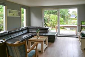 un salon avec un canapé en cuir noir et une table dans l'établissement 120 Dijkrose, à Anjum