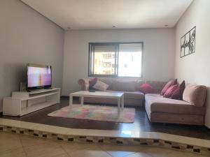 a living room with a couch and a tv at Appart bacha in Kenitra