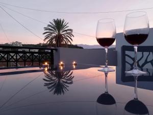 two glasses of wine sitting on top of a table at Emmanuel apartment in Agia Marina Nea Kydonias