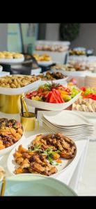 Una mesa con muchos platos de comida encima. en EL Golfview, en De Deur